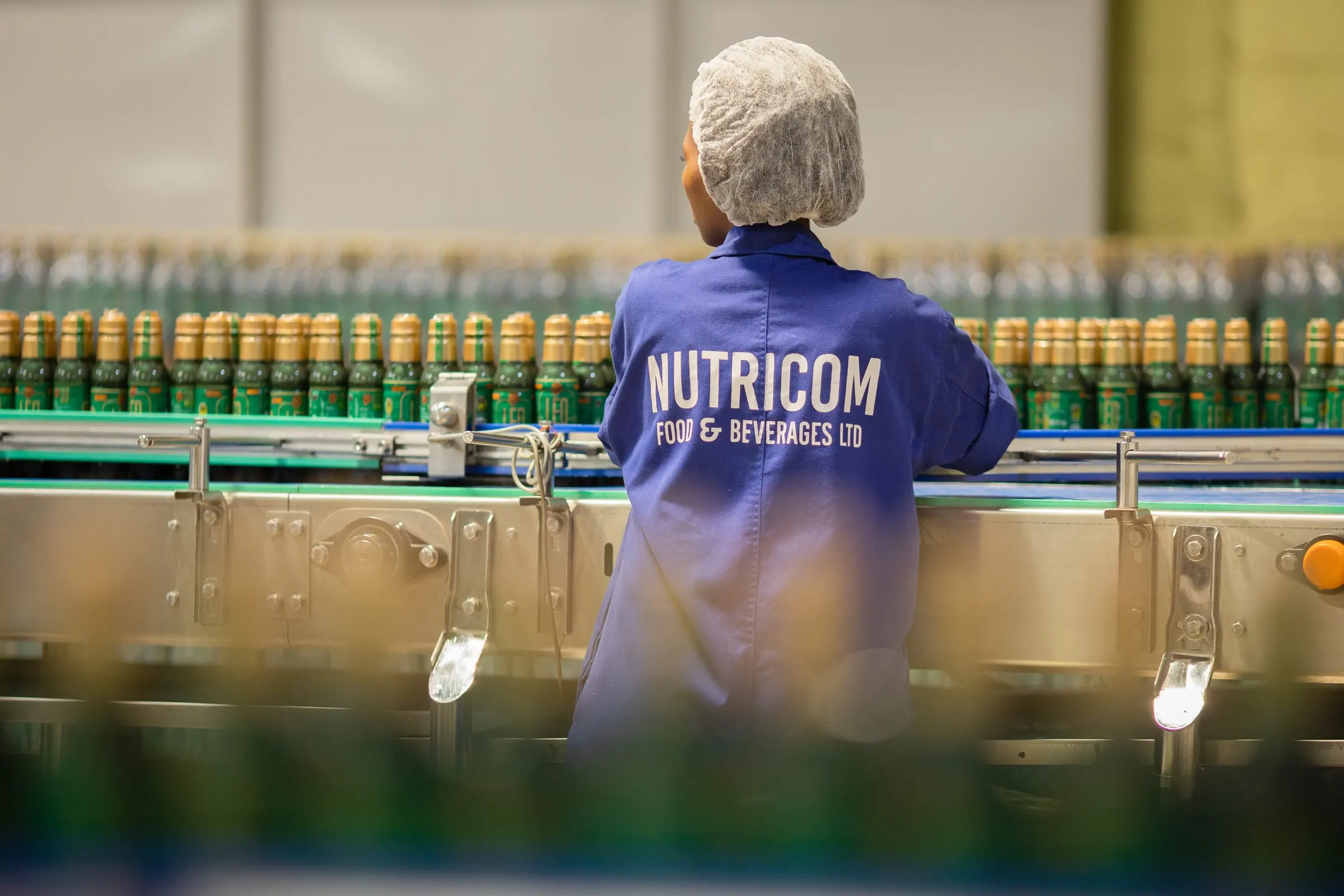 A Nutricom line operator working alongside the filling line.